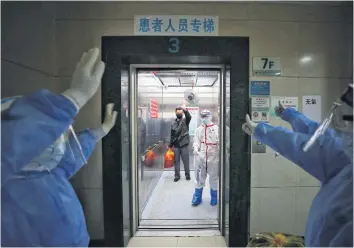  ?? AFP ?? Medical staff wave goodbye to a recovered Covid-19 patient at the Red Cross Hospital in Wuhan in China’s central Hubei province on Monday.