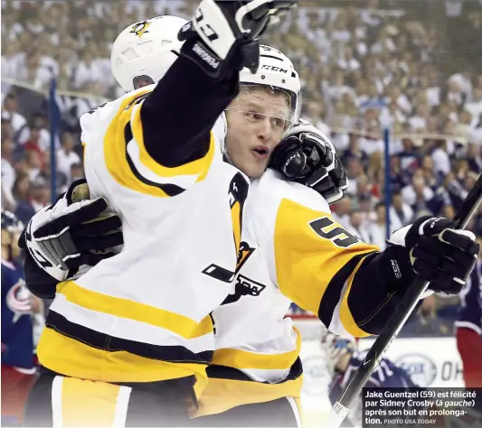  ??  ?? Jake Guentzel (59) est félicité par Sidney Crosby ( à gauche) après son but en prolongati­on.