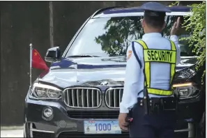  ?? (AP/Aaron Favila) ?? A security guard signals to a car with diplomatic plates and a Chinese flag as he parks at the Philippine Department of Foreign Affairs in Manila, Philippine­s, in August 2023.