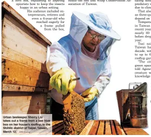  ?? AFP-Yonhap ?? Urban beekeeper Sherry Liu takes out a frame from a bee hive box on her house’s rooftop, in the Shihlin district of Taipei, Taiwan, March 12.