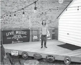  ?? Denton Record-Chronicle via AP ?? Denton High School junior Daniel Gould stands on the outdoor stage at Killer’s Tacos, the all-ages venue where the 17-year-old books music shows, in Denton. Gould recently got a job with Dallas-based Third String Production­s as the head of operations...