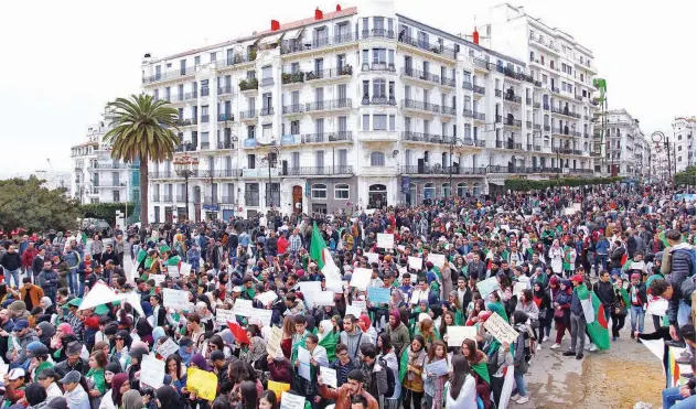  ?? Agence France-presse ?? ↑ Algerians carry placards and national flags as they take part in a demonstrat­ion in the capital Algiers against Abdelaziz Bouteflika.