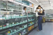  ??  ?? CUSTOMERS buy medicines at a pharmacy in Beijing, China July 10, 2007.