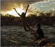  ??  ?? A girl jumps from rocks at Brewarrina Weir in New South Wales, Australia, after the first heavy rainfall in years