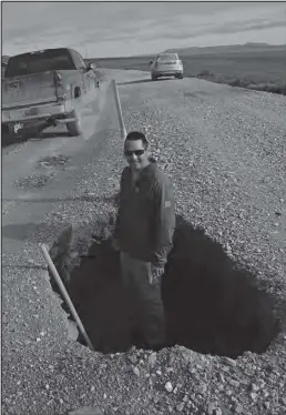  ?? Nugget file photo by Diana Haecker ?? ROAD TO TELLER— This photo taken in July of this year shows only one of the many hazardous features of the Bob Blodgett Nome-Teller Highway. Charles Ellanna volunteere­d to show the scale of this enormous sinkhole near Wooley Lagoon.