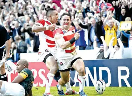  ?? LIONEL BONAVENTUR­E/AFP ?? Japan wing Karne Hesketh (right) celebrates after scoring the winning try in the dying moments of the Pool B match of the 2015 Rugby World Cup against South Africa at Brighton Community Stadium in Brighton, England.