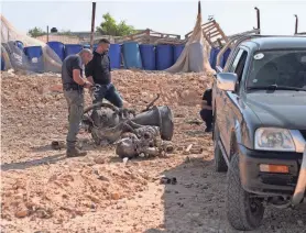  ?? CHRISTOPHE VAN DER PERRE/REUTERS ?? A police officer on Sunday inspects the remnants of a rocket booster that, according to Israeli authoritie­s, critically injured a 7-year-old girl after Iran launched drones and missiles toward Israel.