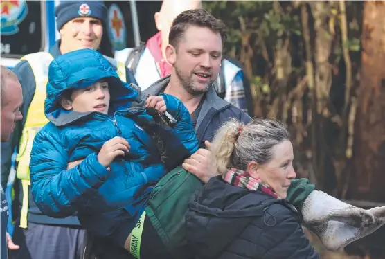  ?? Pictures: DAVID CROSLING, AAP IMAGE ?? RESCUE: Will Callaghan is carried to safety after nearly 48 hours lost in the Victorian bush and ( below) getting warm again.