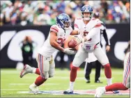  ?? Emilee Chinn / Getty Images ?? The Giants’ Daniel Jones hands off the ball to Saquon Barkley during the second half against the Jets at MetLife Stadium in 2019.