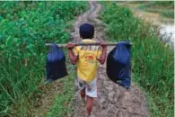  ?? - Reuters ?? FLEEING PERSECUTIO­N: A Rohingya refugee boy carries his belongings as he walks to a makeshift camp in Cox’s Bazar, Bangladesh on Monday.