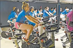  ??  ?? Clara Bailey, a junior, takes part in a spin class that lets riders pedal through a virtual course, Oct. 16 at Carl Sandburg High School in Orland Park.