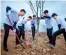  ??  ?? School kids playing cuju, a kind of football, in their traditiona­l Chinese dress. Young men working together to plant a tree.