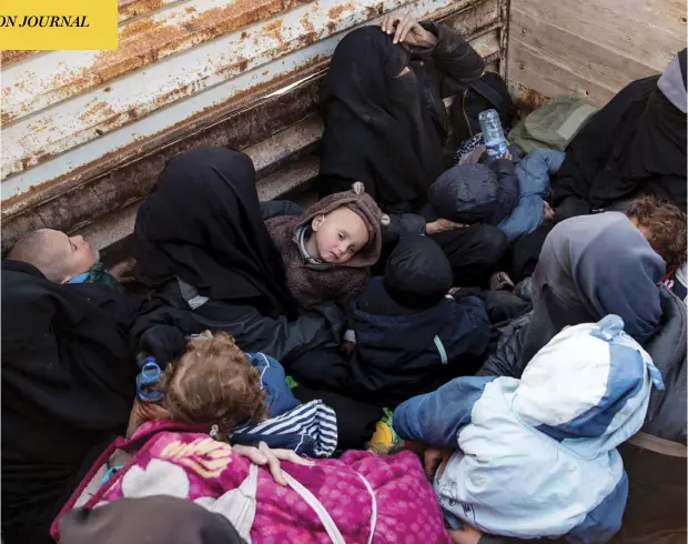  ?? FADEL SENNA / AFP / GEtty ImAGES ?? Women and children fleeing from the last Islamic State group’s tiny pocket in Syria sit in the back of a truck near Baghuz, eastern Syria, on Monday, as the U.S.-backed Syrian Democratic Forces fighters pushed to retake a last territory from ISIL fighters, many of them foreigners.