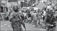  ?? AP/ABBAS DULLEH ?? Liberian soldiers watch for signs of Ebola infection Saturday as they enforce a quarantine among people hoping to take supplies to relatives inside the cordoned-off West Point area of Monrovia.