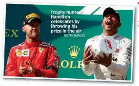  ?? GETTY IMAGES ?? Trophy hunter: Hamilton celebrates by throwing his prize in the air