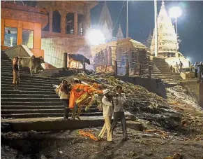  ??  ?? Final journey: Doms carrying a body for cremation at the Manikarnik­a ghat in the old quarters of Varanasi. — AFP