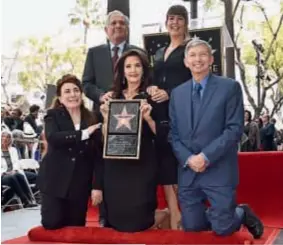  ??  ?? Con los brazos cruzados sobre su pecho, en la pose que la volvió famosa. Así posó la actriz durante su tributo en el pasaje más afamado de Hollywood.