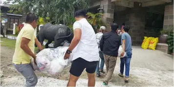  ??  ?? FOR THE COMMUNITY. HAU employees unite in distributi­ng relief goods for parishione­rs of Nuestra Señora del Pilar Parish who were affected by recent typhoons.