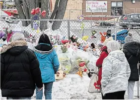  ?? GRAHAM HUGHES THE CANADIAN PRESS ?? Family and neighbours have created a memorial at the site of a daycare centre in Laval, Que., where a bus crashed into the building killing two children.