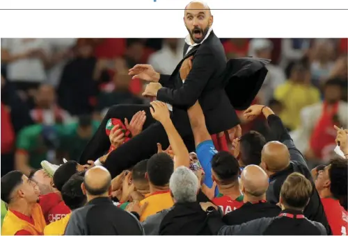  ?? AFP ?? Morocco’s players carry their coach Walid Regragui as they celebrate after winning the Qatar 2022 World Cup quarter- nal football match between Morocco and Portugal at the Al-Thumama Stadium in Doha.