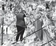  ?? DAVID ZALUBOWSKI/AP ?? Tributes cover the temporary fence around the King Soopers grocery store in which 10 people died in a mass shooting in late March in Boulder, Colorado.