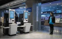  ??  ?? At Hema’s checkout stations, customers scan their groceries and pay using facial recognitio­n, while bags of groceries ordered online float above them on aerial conveyers bound for a loading dock.