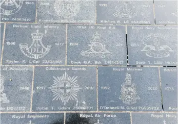  ??  ?? Granite slabs are engraved with names, regimental badges and years of service