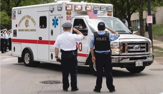  ??  ?? ASHLEE REZIN GARCIA/SUN-TIMES Officers salute outside the Cook County medical examiner’s office as the ambulance carrying the body of CPD Deputy Chief Dion Boyd passes.