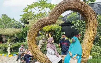  ?? RIANA SETIAWAN/JAWA POS ?? TUNGGU INSTRUKSI: Warga menikmati suasana Taman Anggrek di Kawasan Sememi. Hingga saat ini, taman budi daya anggrek belum dibuka karena pandemi.