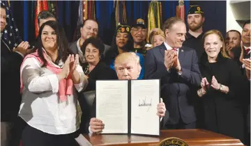  ?? (Olivier Douliery/Abaca Press/TNS) ?? PRESIDENT DONALD TRUMP signs the Executive Order on Improving Accountabi­lity and Whistleblo­wer Protection at the Department of Veterans Affairs in Washington, last week.