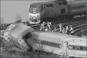  ??  ?? DERAILED: In this Dec. 1, 2013, file photo, an Amtrak train, top, traveling on an unaffected track, passes a derailed Metro North commuter train in the Bronx borough of New York. President Donald Trump is putting the brakes on attempts to address...