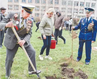  ??  ?? Марина Новицкая (в центре), ветераны и другие участники субботника заложили яблоневый сад.