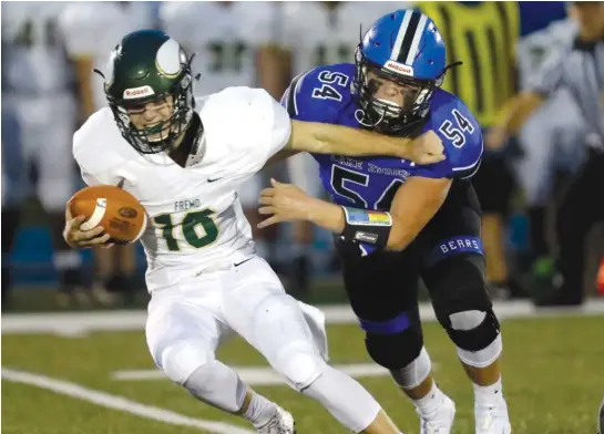  ?? STEVE LUNDY/DAILY HERALD ?? Fremd quarterbac­k Andrew Saxe tries to avoid Lake Zurich’s Vinnie Panico during Week 1 action Friday night. The Bears beat the Vikings 20-7.