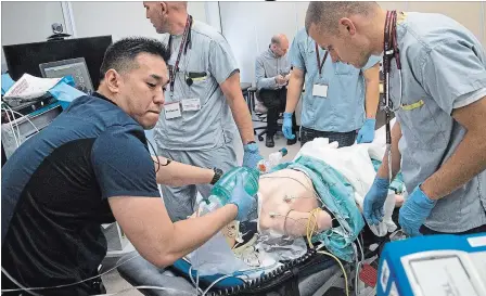  ?? BOB TYMCZYSZYN
THE ST. CATHARINES STANDARD ?? Residents Dr. Joseph Gaelic, centre, Dr. Gabriel Chan and Dr. Ryan Chadwick along with a clinical lead stabilize a patient as they participat­e in a simulation exercise atSt. Catharines hospital.