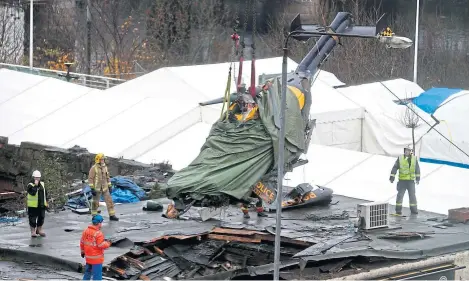  ?? Picture: PA. ?? The wreckage of the police Eurocopter being lifted from the Clutha Bar roof after the tragedy.