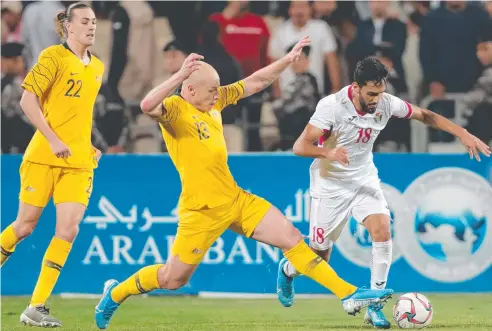  ??  ?? TOO STRONG: Jordan forward Musa Al-Taamari is tackled by Australia's midfielder Aaron Mooy as Jackson Irvine looks on in Amman.