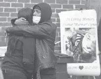  ?? BRAD HORRIGAN/HARTFORD COURANT ?? Two people embrace at a vigil for Shamar Ogman on Wednesday afternoon on Gilman Street in Hartford, where Ogman was shot and killed by police.