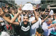  ?? — Reuters ?? Protesters chant slogans during a protest against the new income tax law and high fuel prices in Amman on Friday. The banner reads in Arabic “we do not have money”.