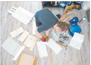  ?? Alex Kormann Minneapoli­s Star Tribune ?? Molly Mcgee builds a Hemnes three-drawer nightstand from IKEA for Kirsten Berg. She previously built Berg’s eight-drawer dresser from the same collection. The entire process took Mcgee under 45 minutes.