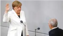  ?? - Reuters/Kai Pfaffenbac­h ?? TAKES OATH OF OFFICE: German Chancellor Angela Merkel is sworn-in by Parliament President Wolfgang Schaeuble during a meeting of Germany’s lower house of parliament Bundestag in Berlin, Germany, March 14, 2018.