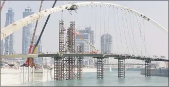  ??  ?? Constructi­on laborers work on a pedestrian bridge over the 2 mile (3.2 kms), Dubai Canal in Dubai, United Arab Emirates on Oct 24. Water has been released to the canal as a part of a testing phase of the AED 2 billion, about
$548 million, project that...