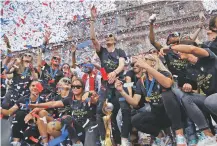  ?? SETH WENIG/ASSOCIATED PRESS ?? Megan Rapinoe, center, and the rest of the U.S. women’s soccer team, celebrate Wednesday at City Hall in New York after a ticker tape parade. The U.S. national team beat the Netherland­s 2-0 to capture a record fourth title.