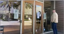  ?? ROXANA POPESCU — THE SAN DIEGO UNION-TRIBUNE ?? Interior designer Bobby Smith peers through the window of the temporaril­y shuttered PIRCH store at Westfield UTC. He's worried now about what will happen to his clients' open orders.