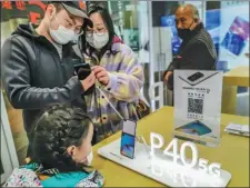  ?? WANG GANG / FOR CHINA DAILY ?? Consumers check out Huawei’s P40 smartphone­s at a Huawei shop in Shanghai.