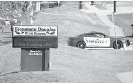  ?? WILFREDO LEE/AP ?? Law enforcemen­t officers block the entrance to Marjory Stoneman Douglas High School in Parkland the day after the mass shooting on Feb. 14, 2018.