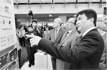  ??  ?? Sharbini (right) giving Chief Minister Datuk Patinggi Abang Johari Tun Openg and Deputy Chief Minister Datuk Amar Awang Tengah Ali Hasan (left) a tour of the Sarawak Energy exhibition booth at the IEW 2018.