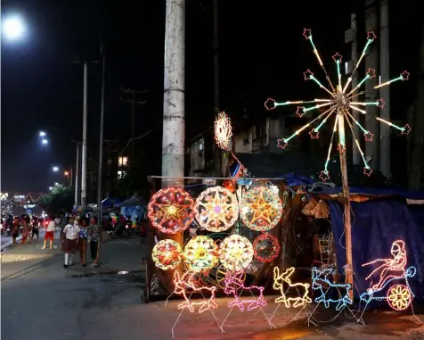  ??  ?? Decoration­s and lanterns light up a stall along Commonweal­th Avenue in Old Balara, Quezon City. As a tradition, Filipinos begin the countdown to Christmas as early as the onset of the ‘ber’ months. (PNA)