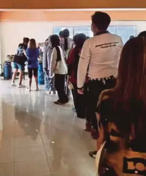  ?? ?? Pelajar dan pensyarah UUM yang terperangk­ap mengambil bubur yang disediakan oleh warga Hatnyai di Wangburapa Grand Hotel.