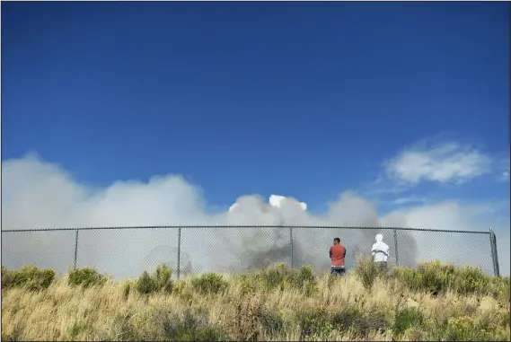  ?? RACHEL ELLIS — THE DENVER POST ?? Michael Perizzolo, left, and brother Joe stand in a field across from East Grand Middle School watching the smoke roll in from the East Troublesom­e fire in Granby on Oct. 22. The 193,812- acre fire exploded from 30,000 acres to 170,000 acres in about 24 hours.