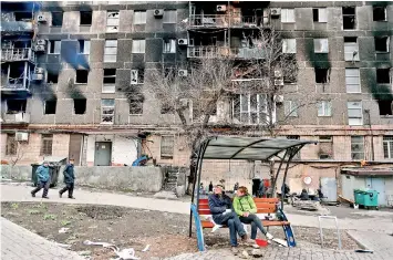  ?? REUTERS/Alexander Ermochenko ?? Local residents gather in a courtyard near an apartment building heavily damaged during Ukraine-Russia conflict in the southern port city of Mariupol, Ukraine April 14, 2022.